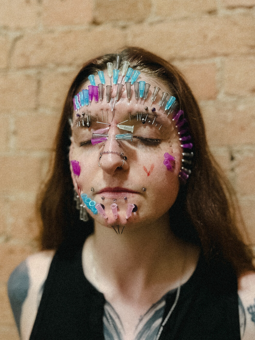 A woman with many needles through her face. 